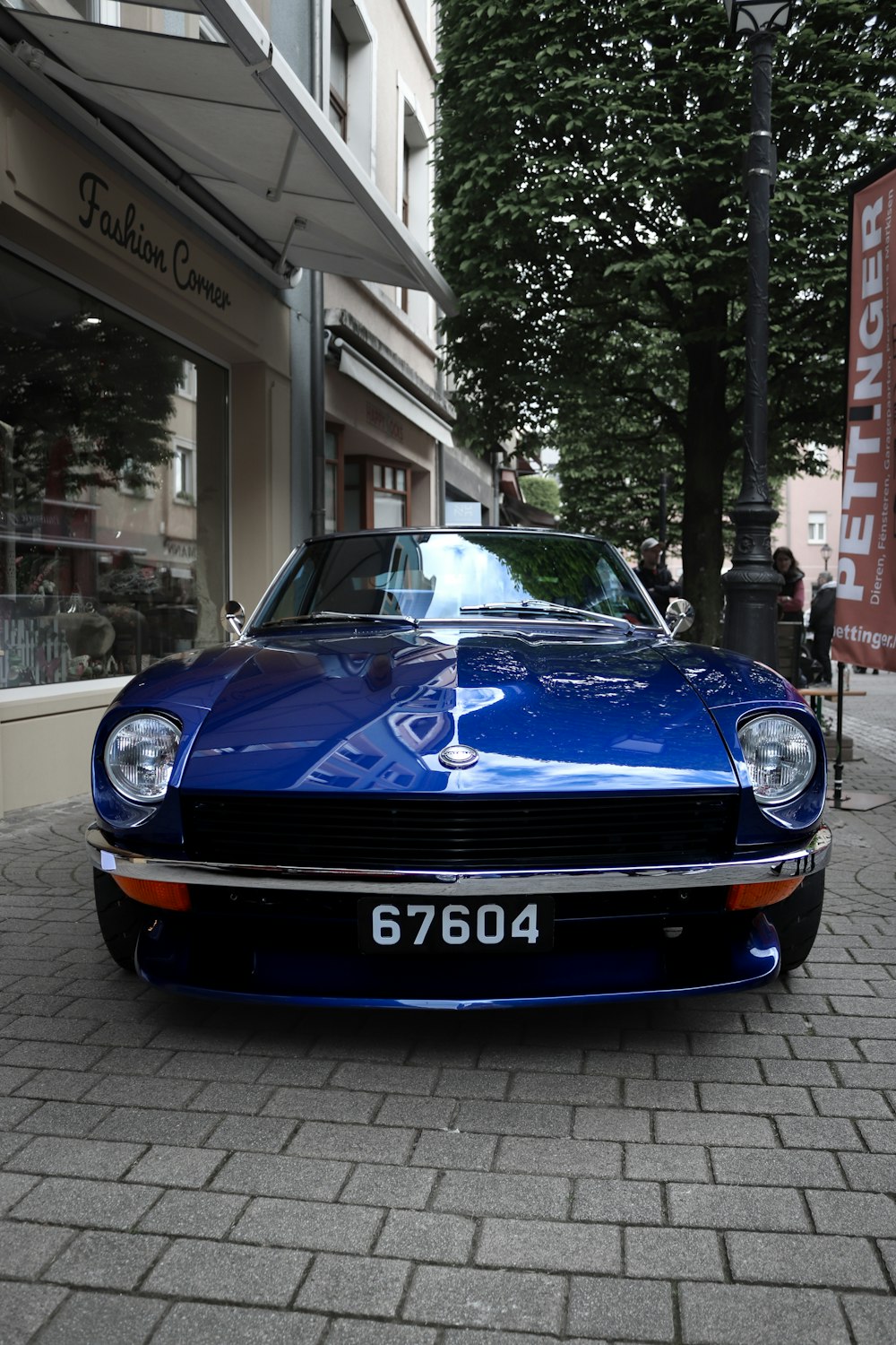 a blue sports car parked in front of a building