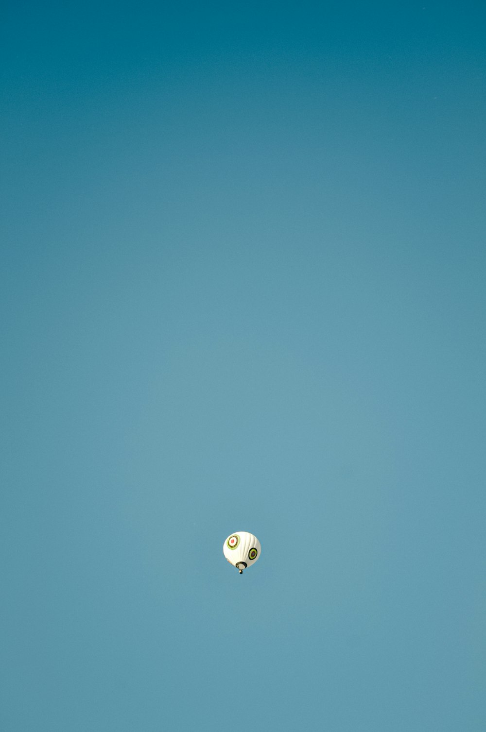 a bird flying through a blue sky with clouds