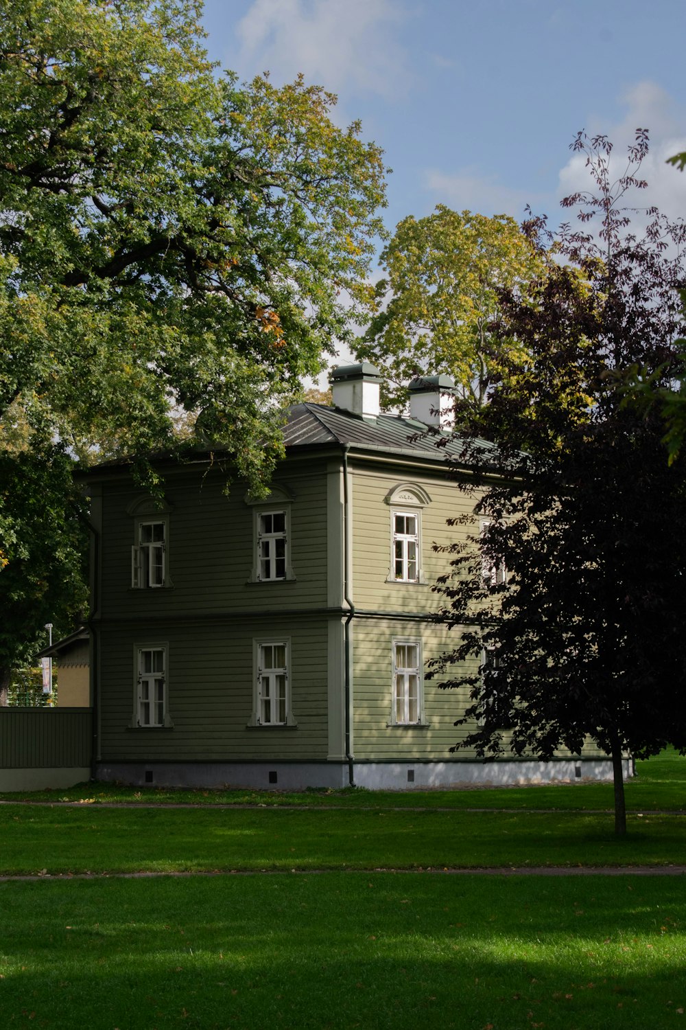 a large green house sitting on top of a lush green field