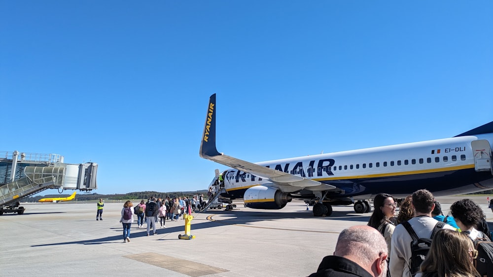 a large group of people standing around a plane