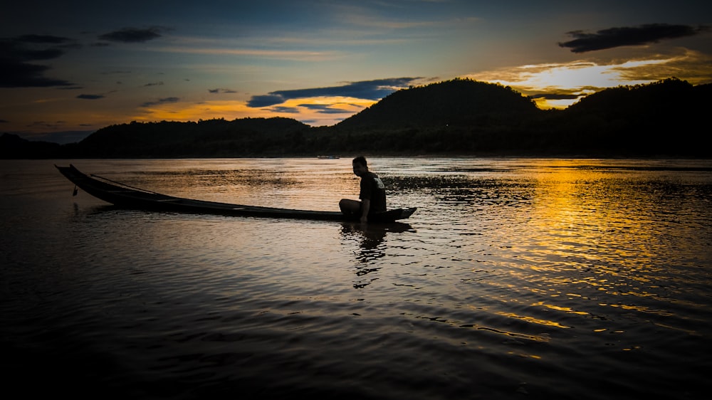 a person sitting in a boat on a lake