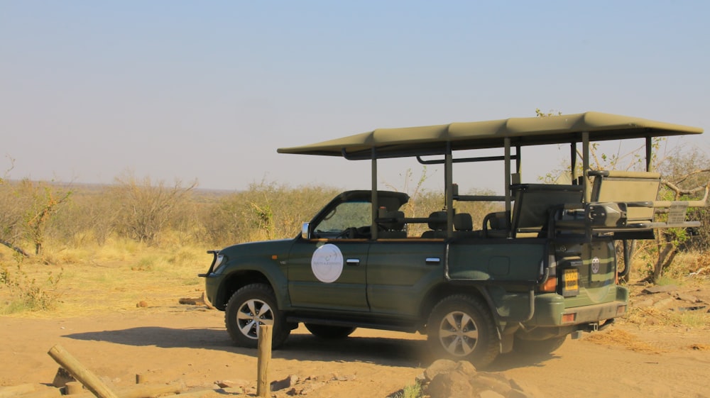 a safari vehicle with a canopy on a dirt road