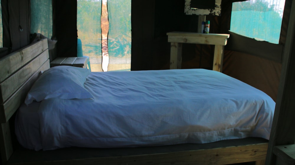 una cama sentada en un dormitorio junto a una ventana