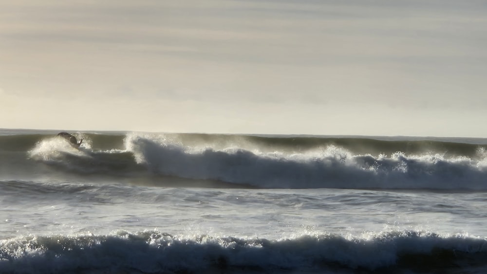 a man riding a wave on top of a surfboard