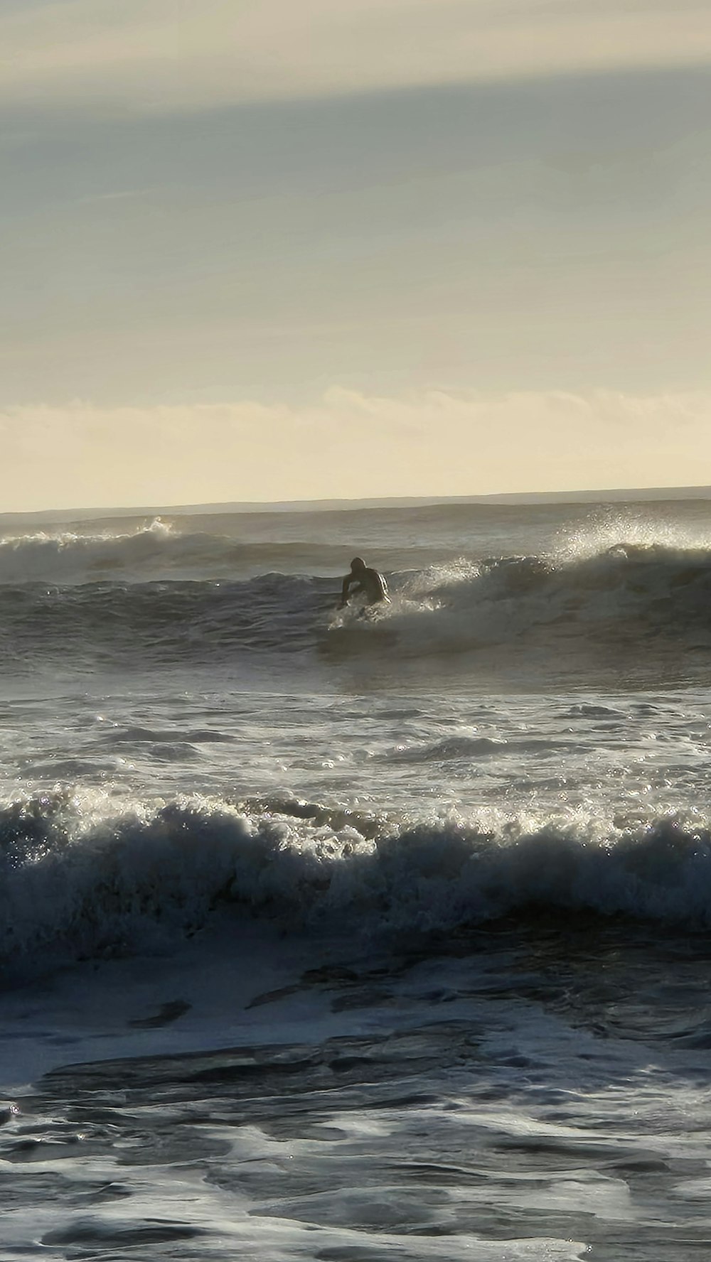 a man riding a wave on top of a surfboard