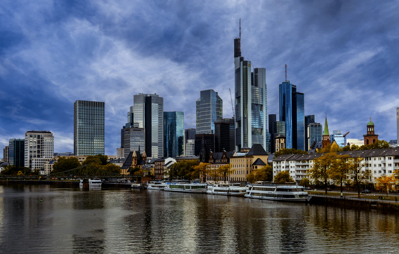View of the Frankfurt am Main skyline at dusk, reflecting warm light over the river