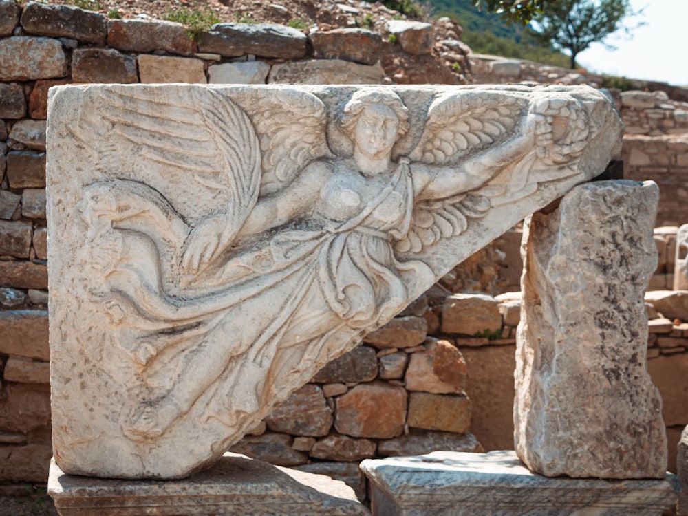 a close up of a stone object with a tree in the background