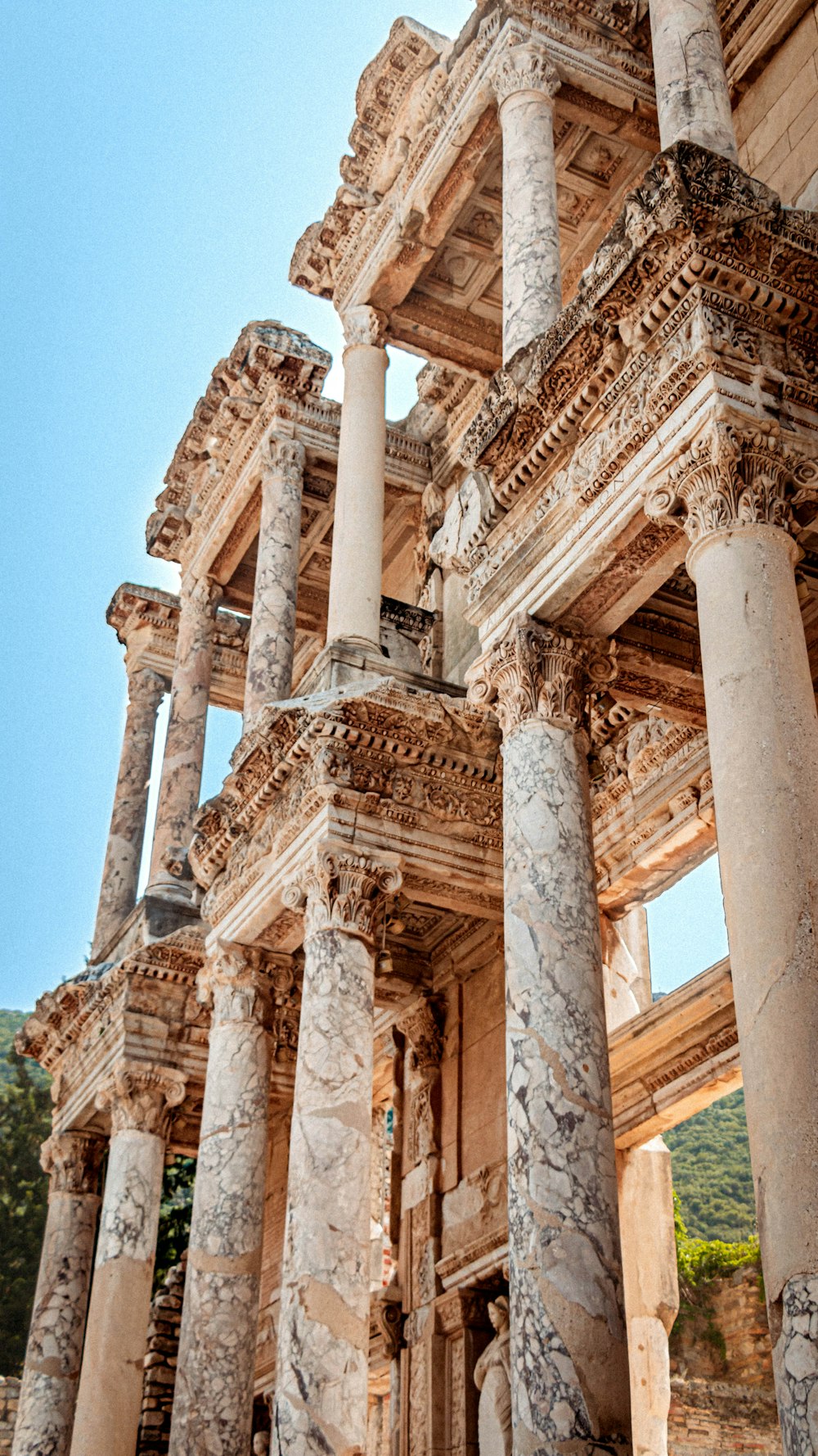 an old building with columns and a clock on the side of it