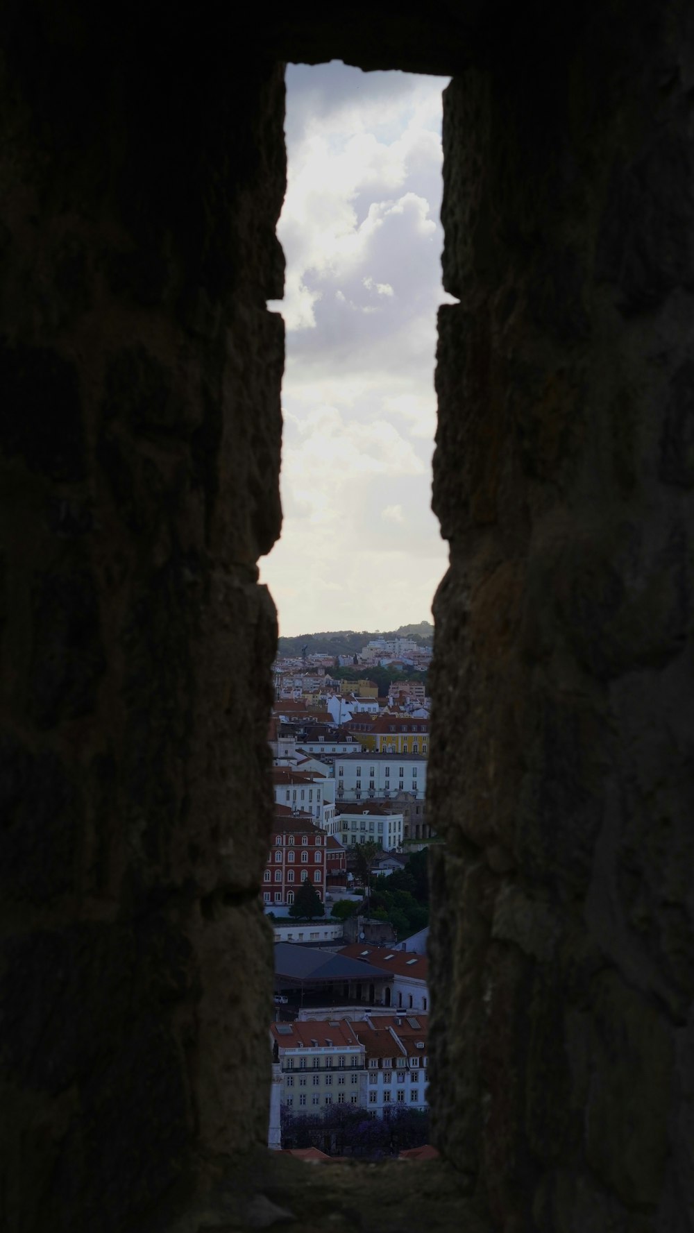 uma vista de uma cidade através de um buraco em uma parede