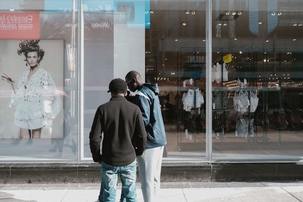 a couple of men standing in front of a store