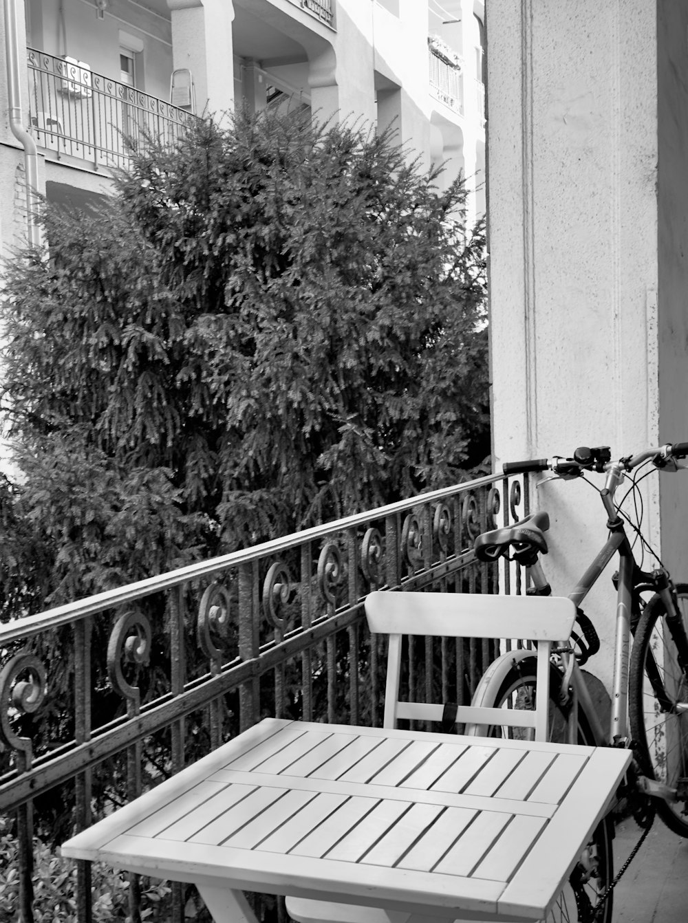 a bicycle parked next to a table on a balcony