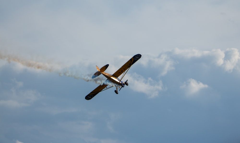 un pequeño avión volando a través de un cielo azul nublado