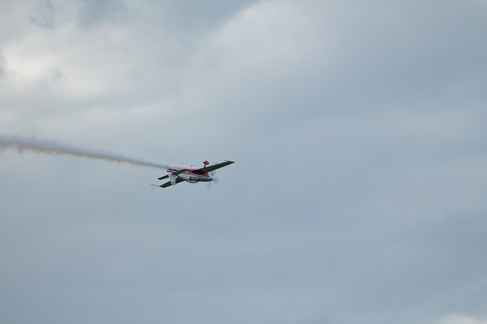 a small plane flying through a cloudy sky