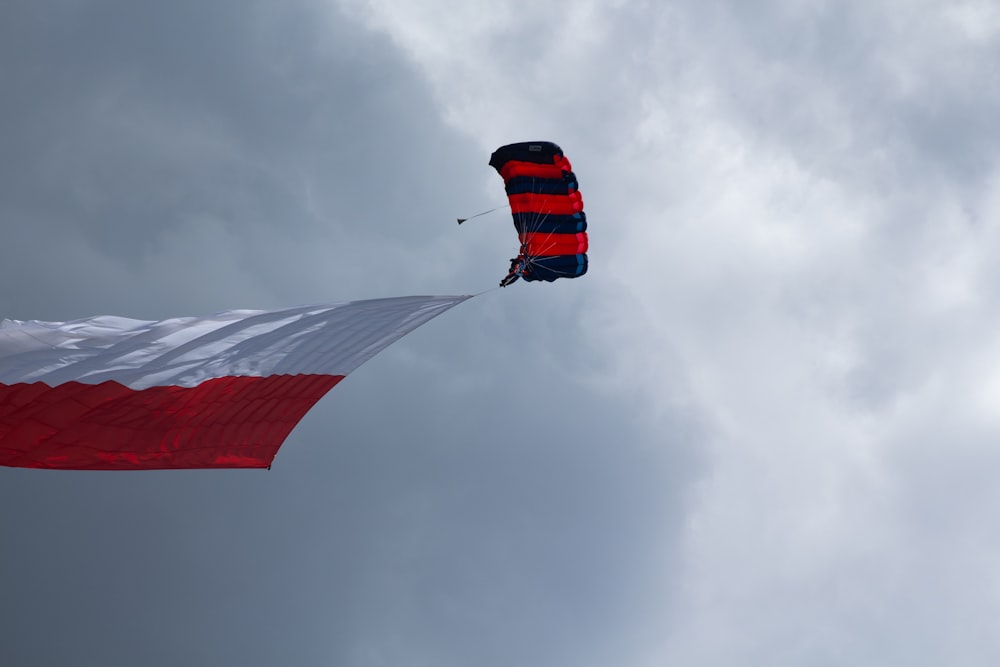 a red, white and blue kite flying in the sky