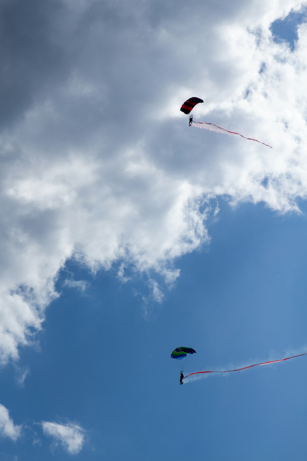 three kites flying in the sky on a cloudy day