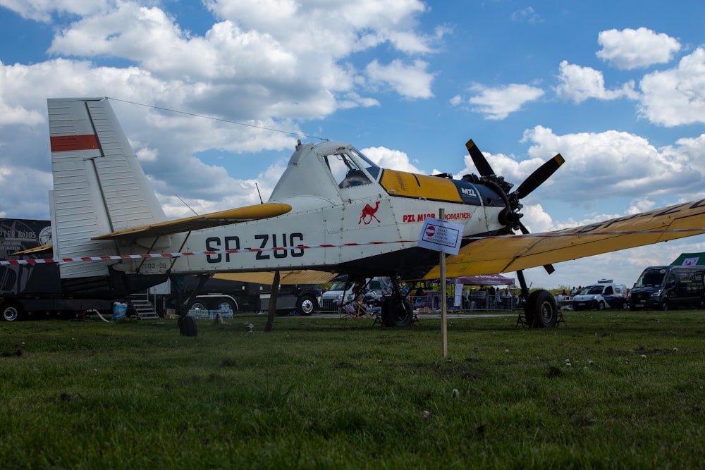 a yellow and white plane parked in a field