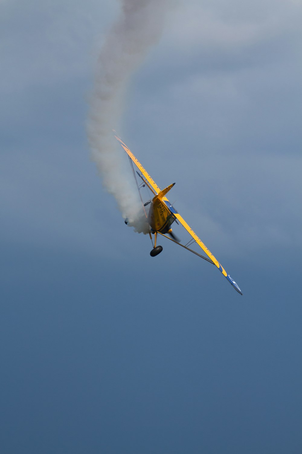 un pequeño avión volando a través de un cielo azul nublado