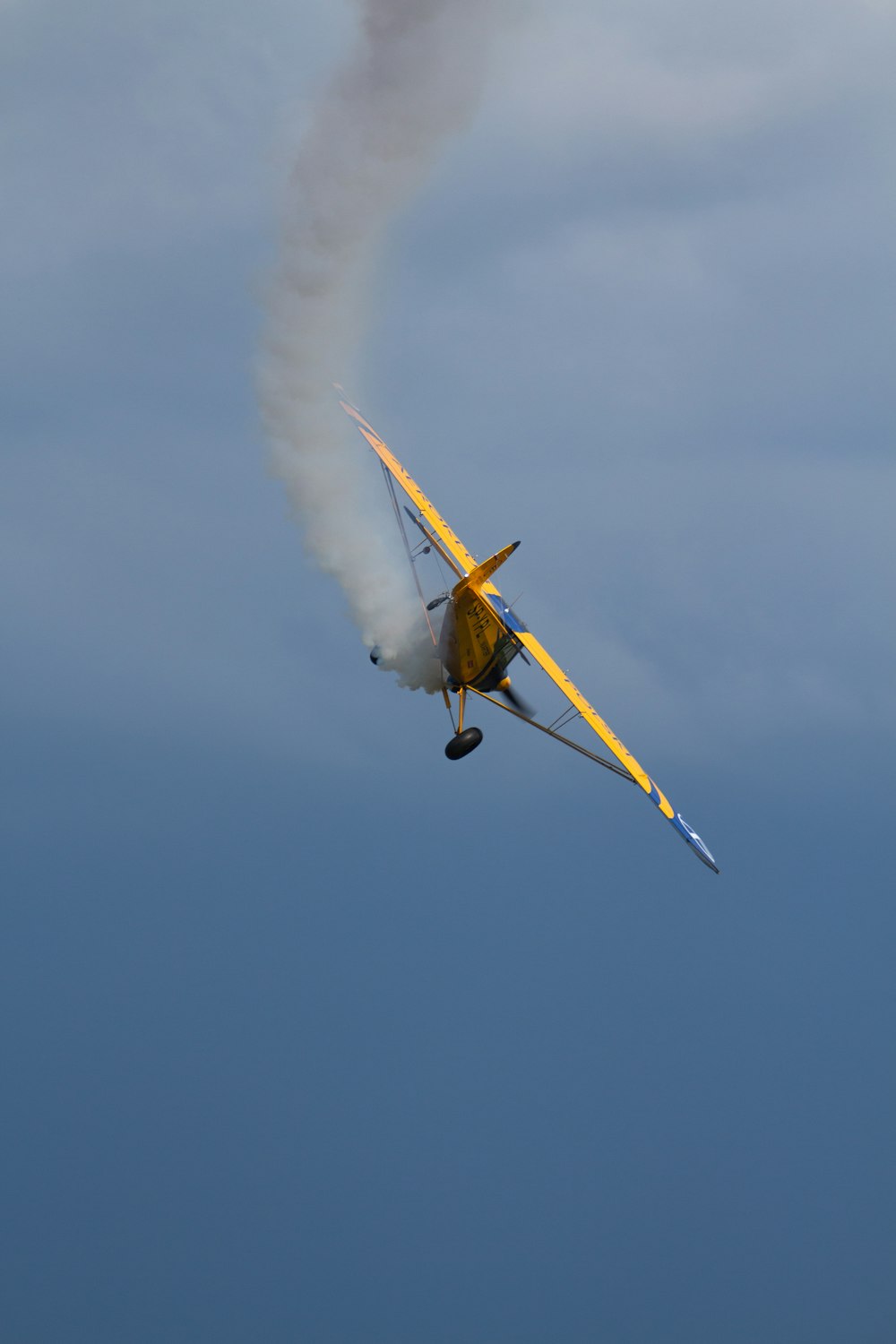 a small airplane flying through a cloudy blue sky