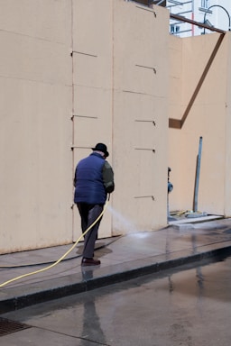 a man is using a hose to clean the street