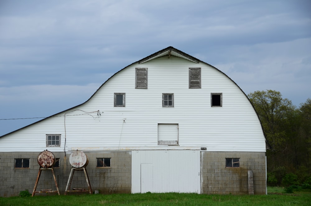 a large white barn with two windows on the side of it