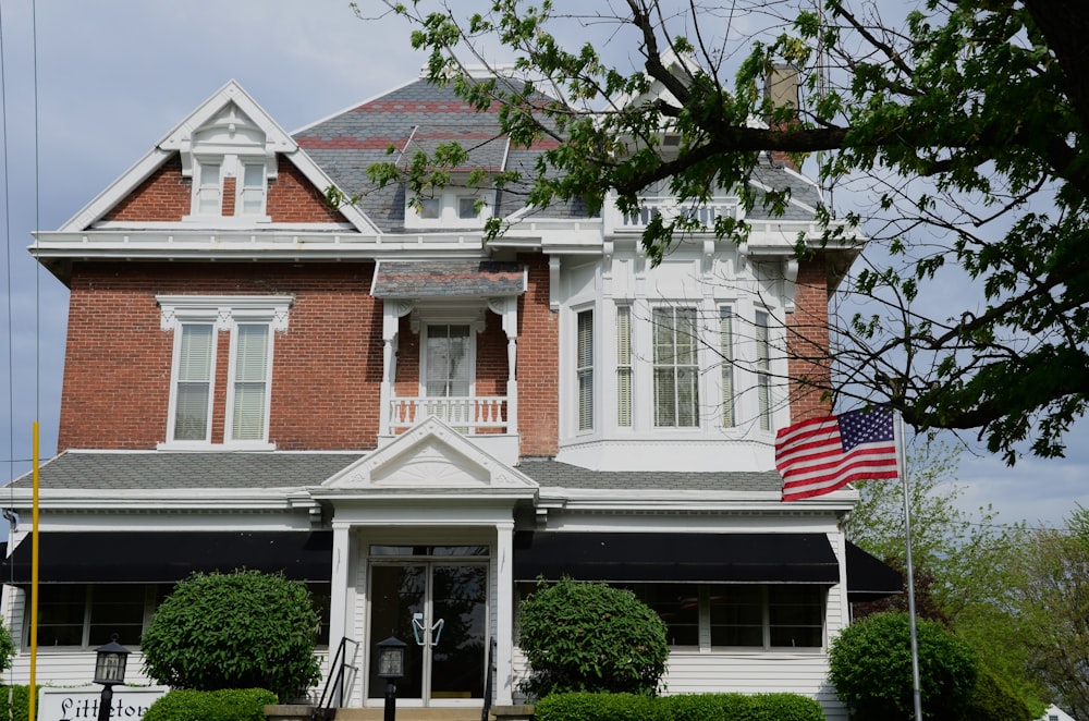 a large brick house with a flag on the front porch