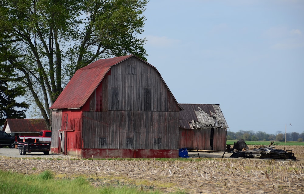 a red barn sits in the middle of a field