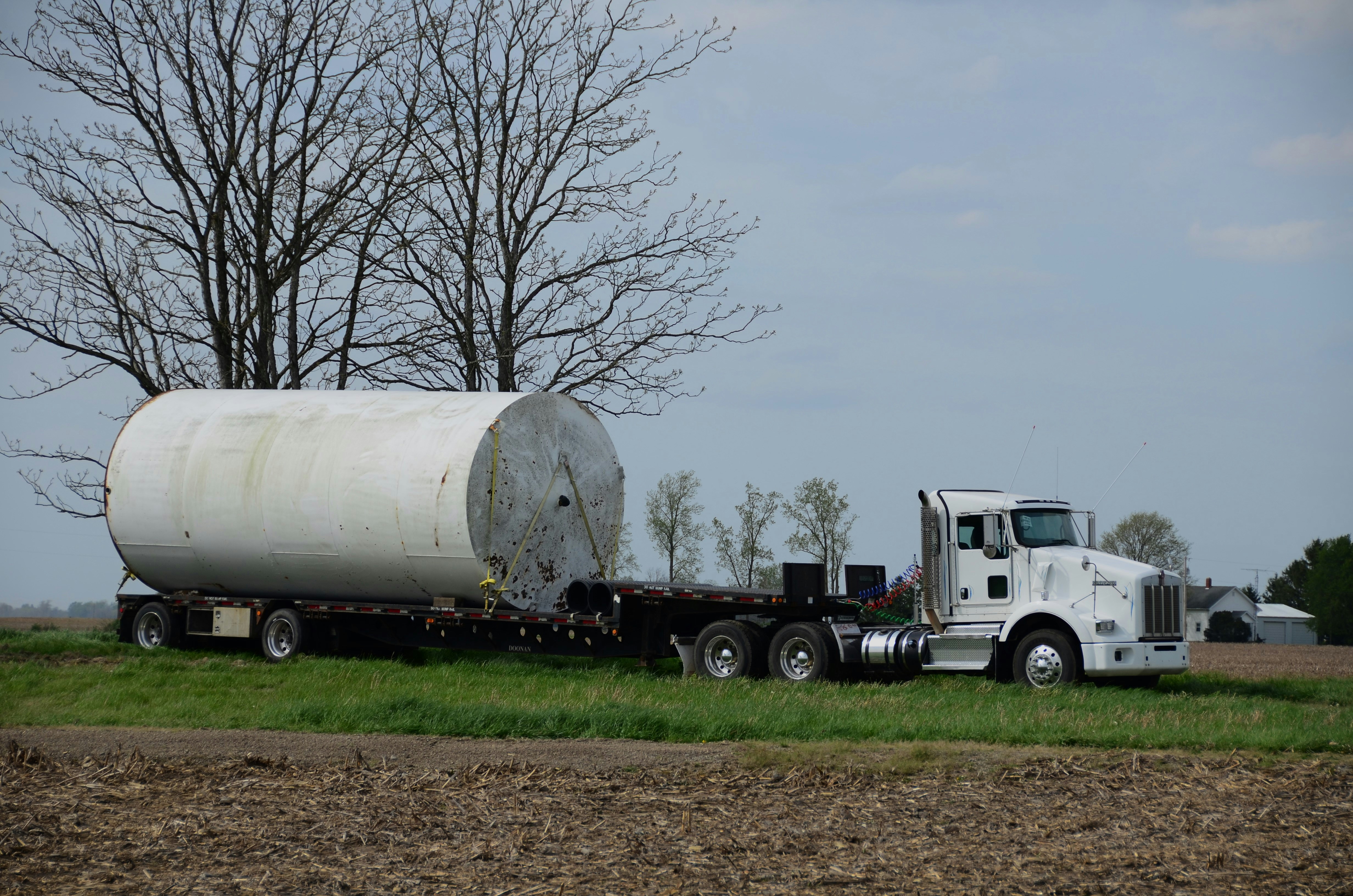 White KW Day Cab tractor with drop deck lowboy trailer and massive tank