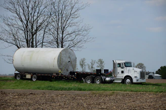 a tractor trailer hauling a large white tank