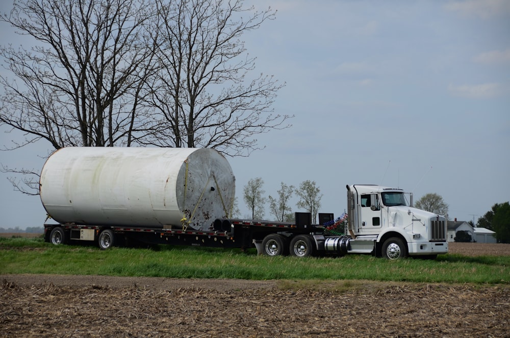 a tractor trailer hauling a large white tank