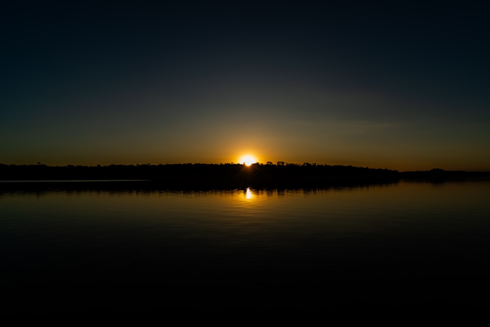 the sun is setting over a body of water