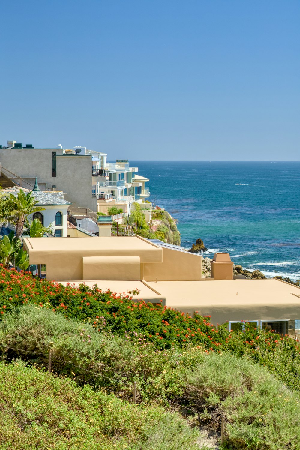 a view of the ocean and houses from a hill