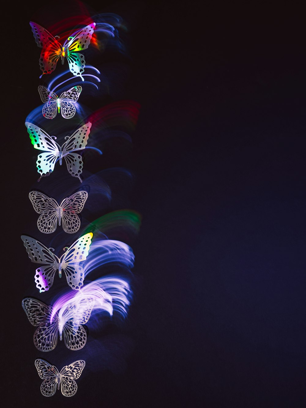 a group of butterflies flying through the night sky