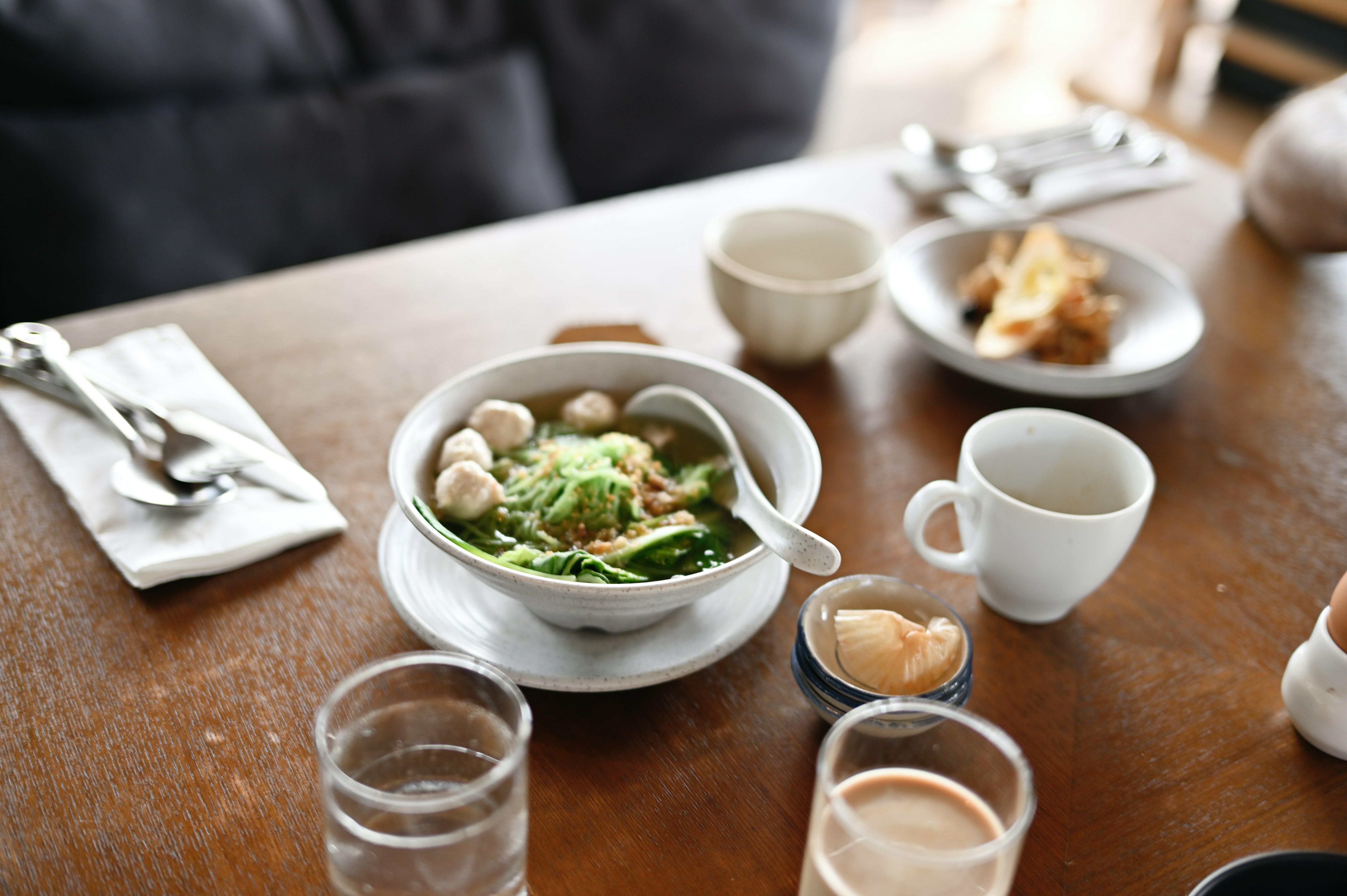 a wooden table topped with a bowl of food