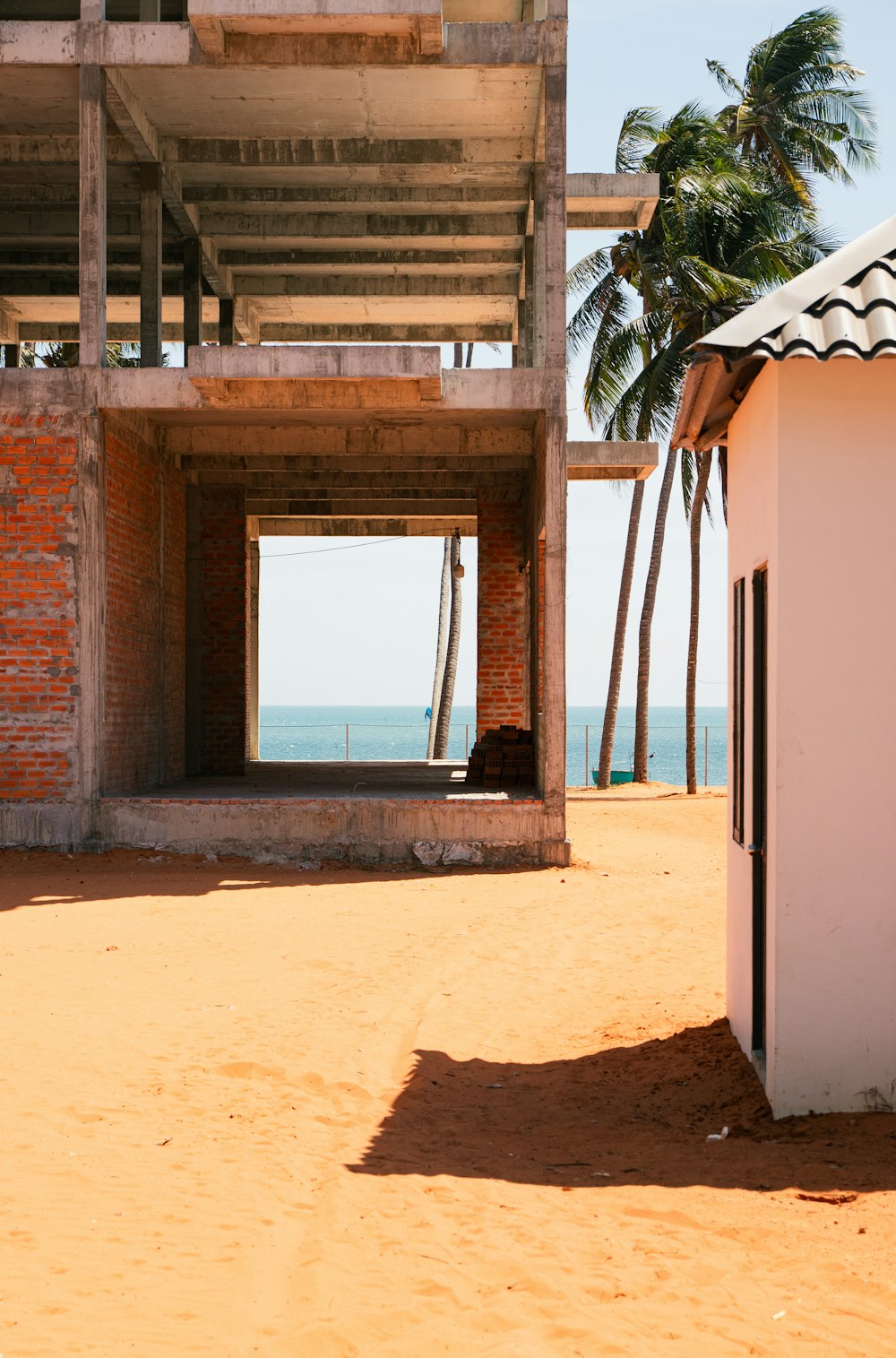 a building on a beach with palm trees in the background