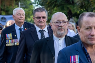 a group of men walking down a street next to each other