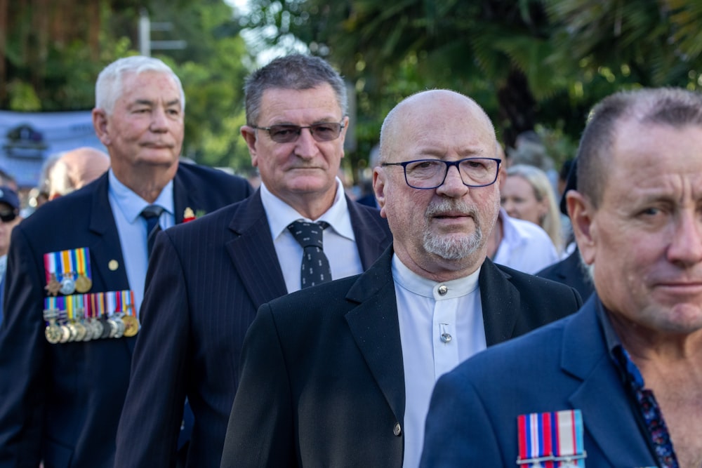 a group of men walking down a street next to each other