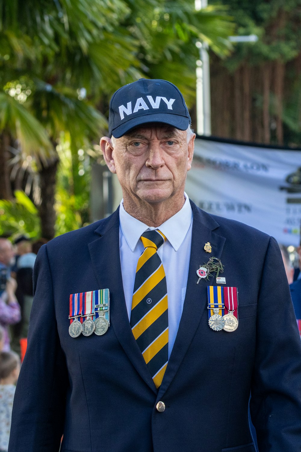 a man in a navy suit with medals on his lapel