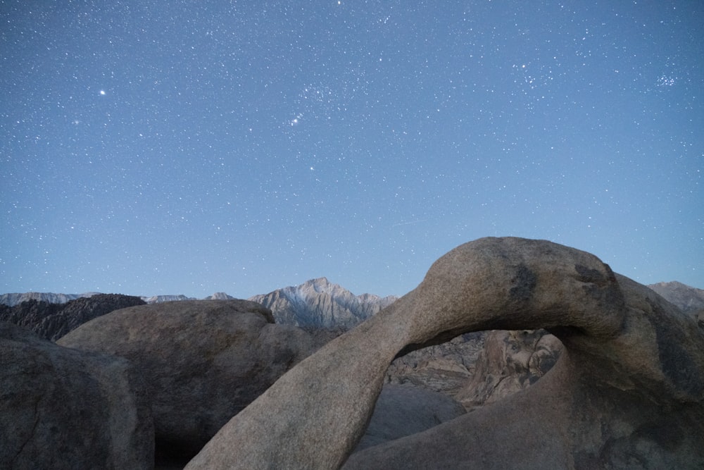 a night sky with stars above some rocks