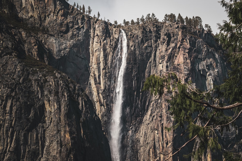 a large waterfall is seen from the bottom of a mountain