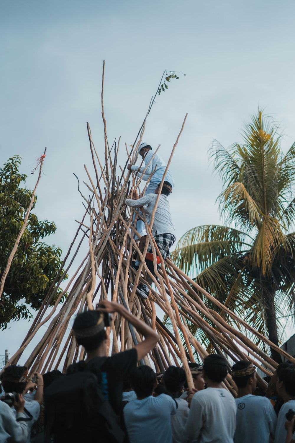 a group of people standing around a pile of sticks