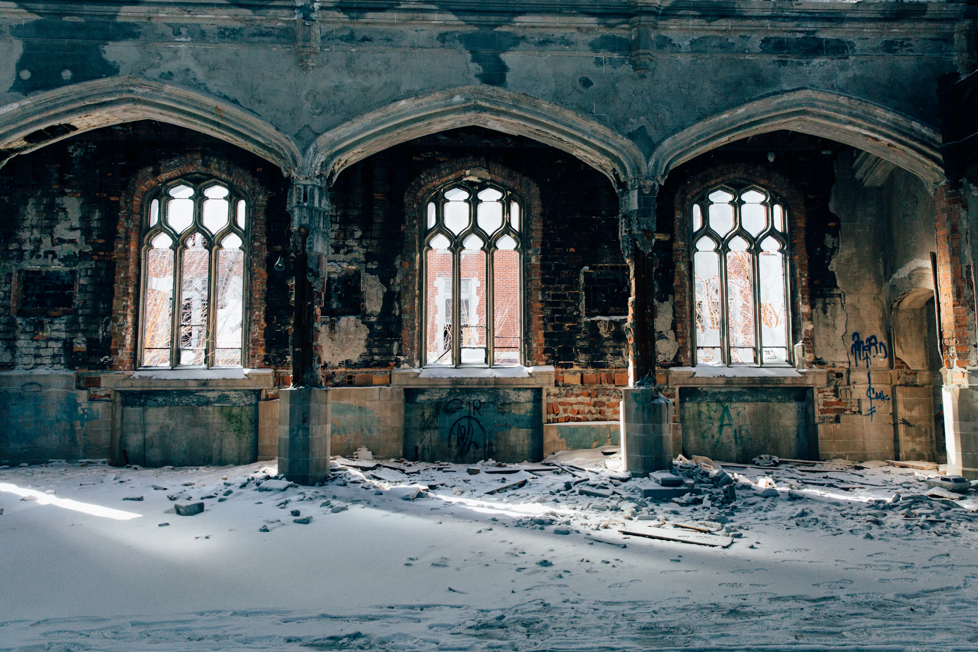 an old building with three arched windows and snow on the ground