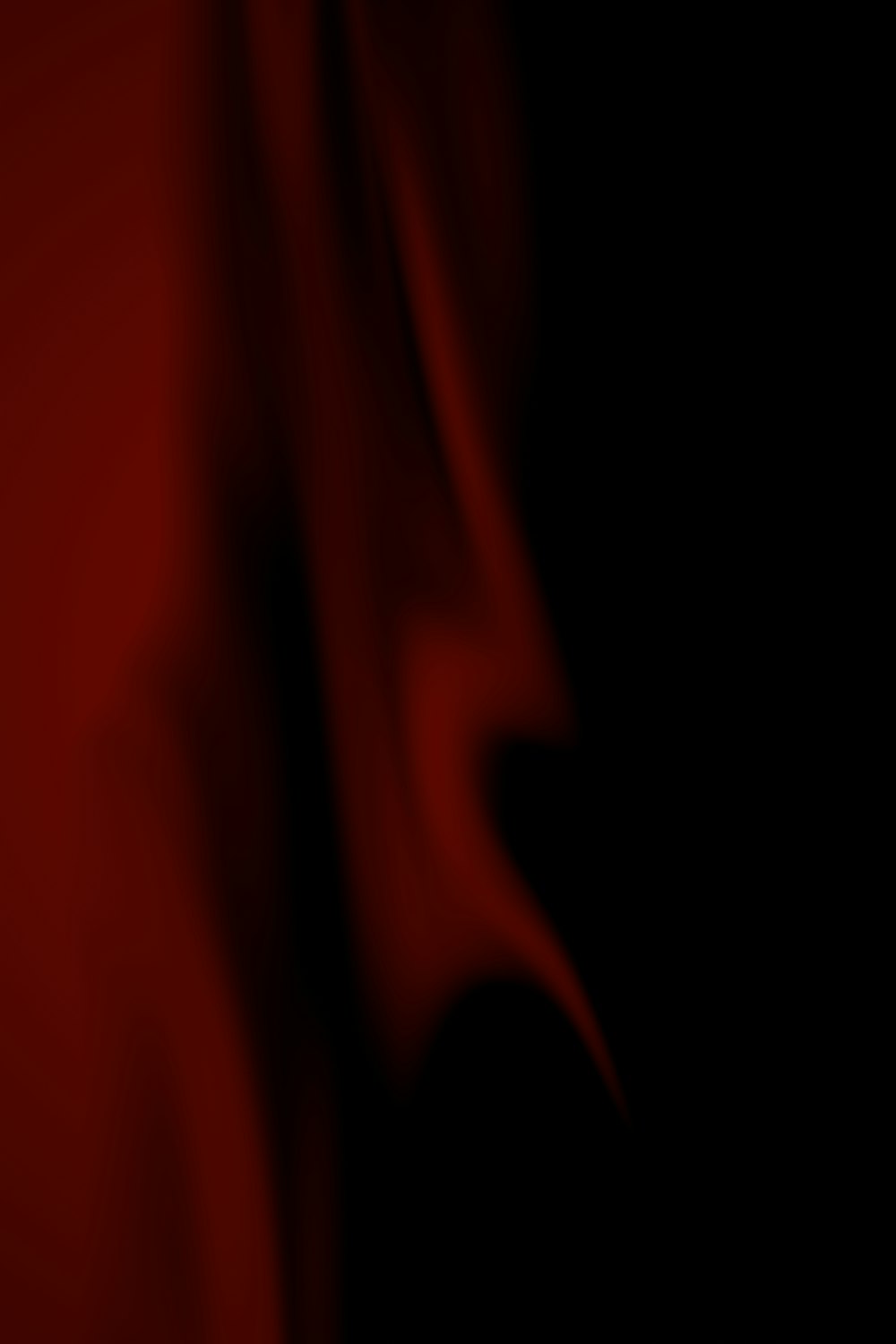 a blurry image of a red cloth on a black background