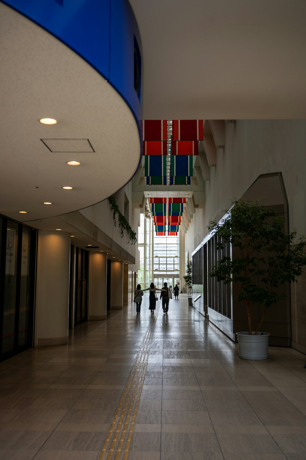 a group of people walking down a long hallway