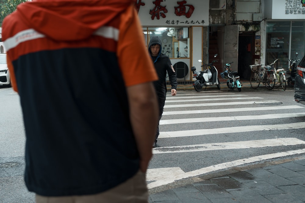 a man walking across a street next to a cross walk