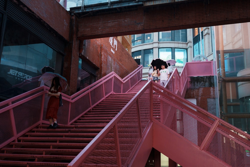 a couple of women walking down a pink staircase