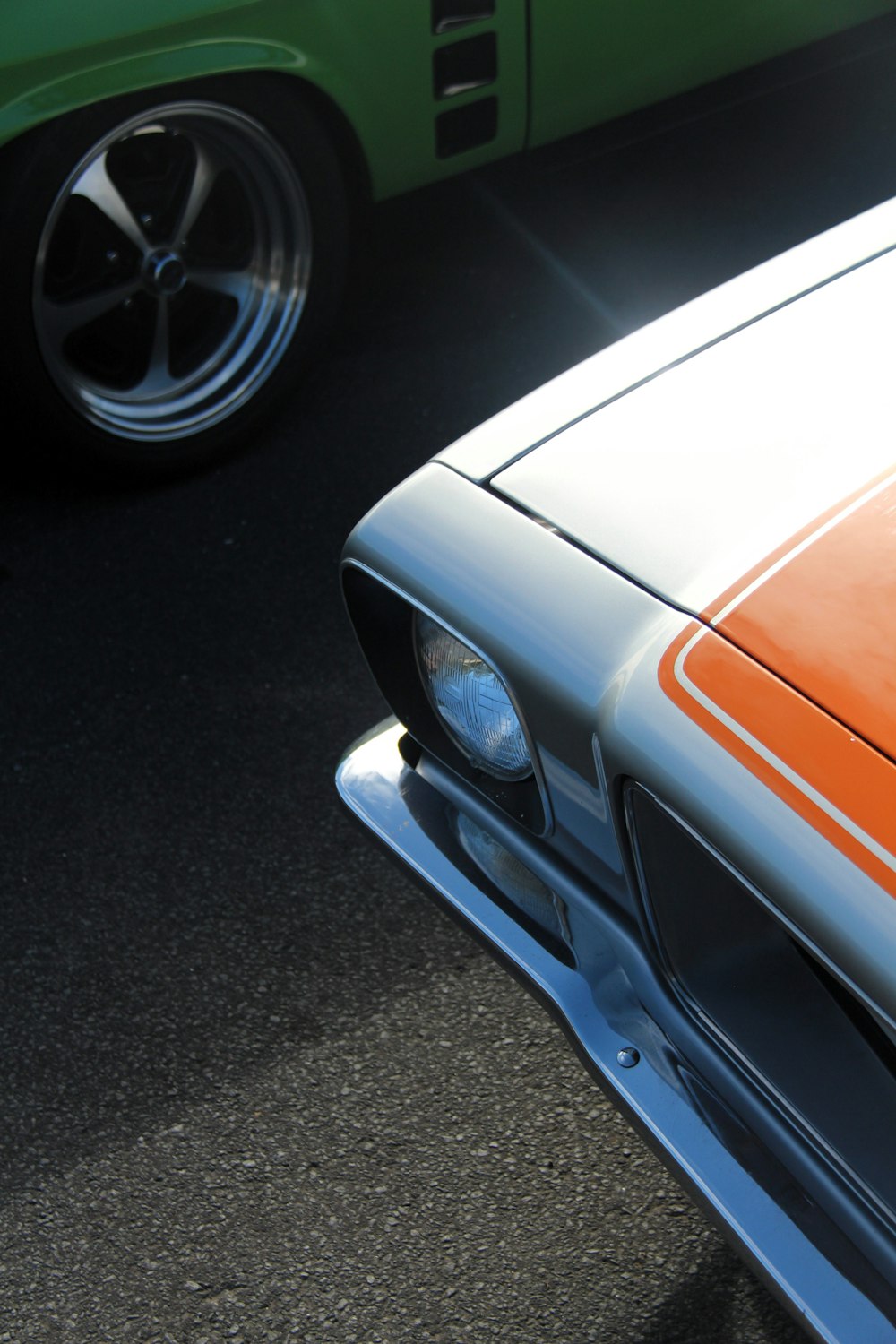 a close up of the front of an orange and white mustang