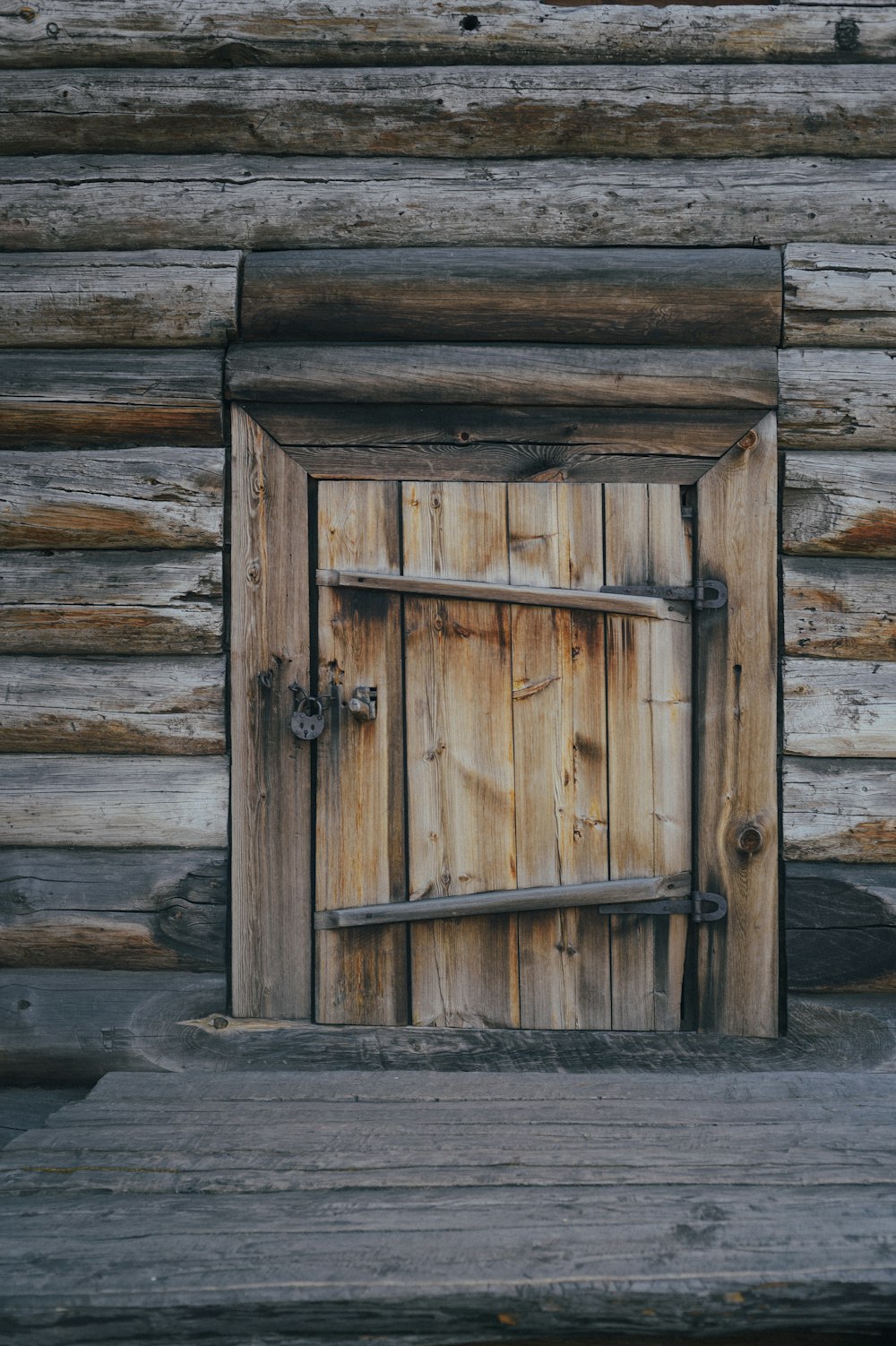 a wooden door is open in front of a log cabin