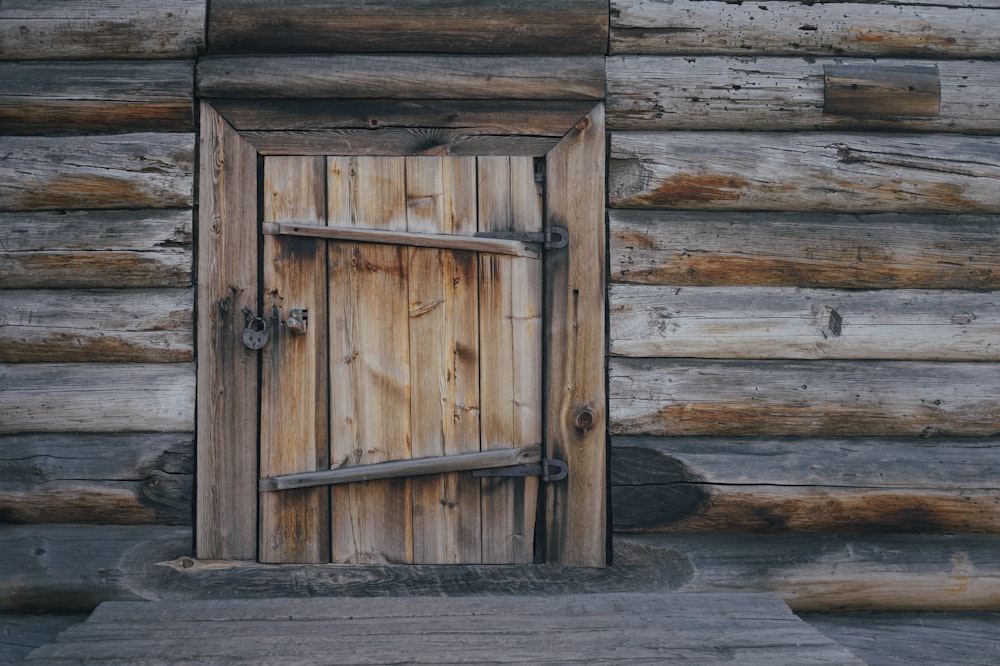 a wooden door is open in front of a log cabin