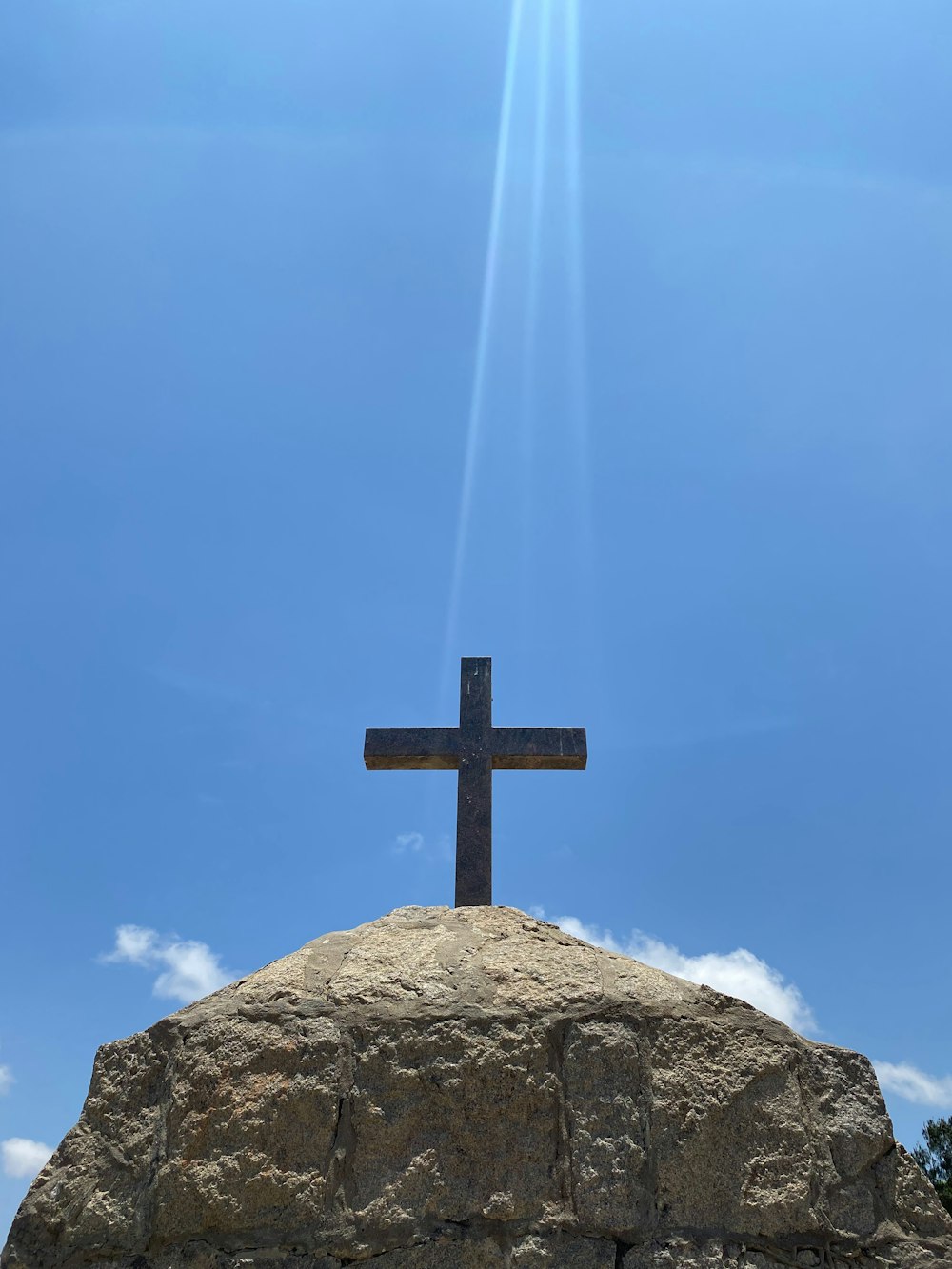 a cross sitting on top of a large rock