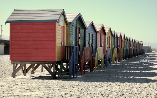 a row of beach huts sitting on top of a sandy beach